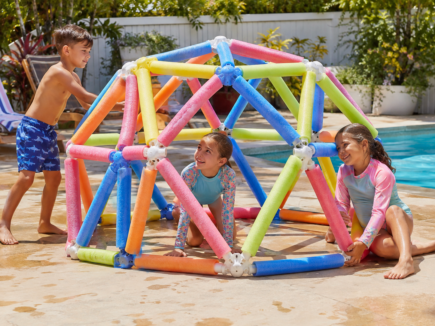 Colorful foam pool noodles stacked into a structure on a pool deck